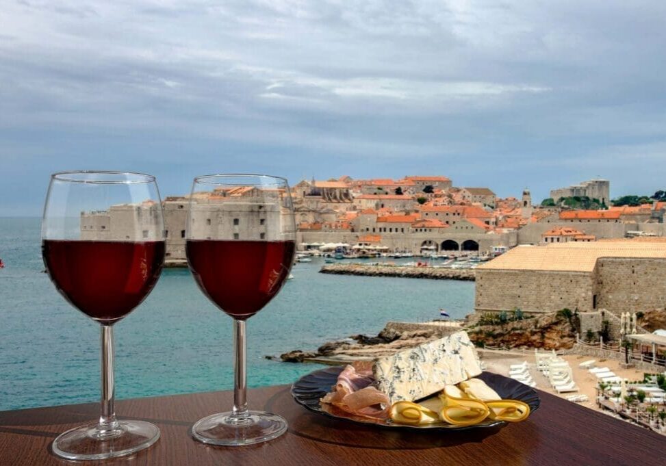 Two glasses of red wine by seaside city